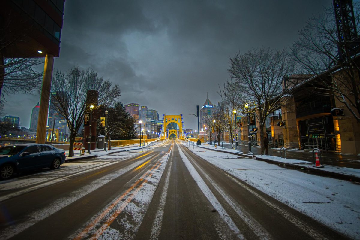 Upon the frozen road, looking through the lens of the golden bridge, the city whispers secrets. Tire tracks etched in ice lead toward Pittsburgh’s heart, where steel meets skyline.